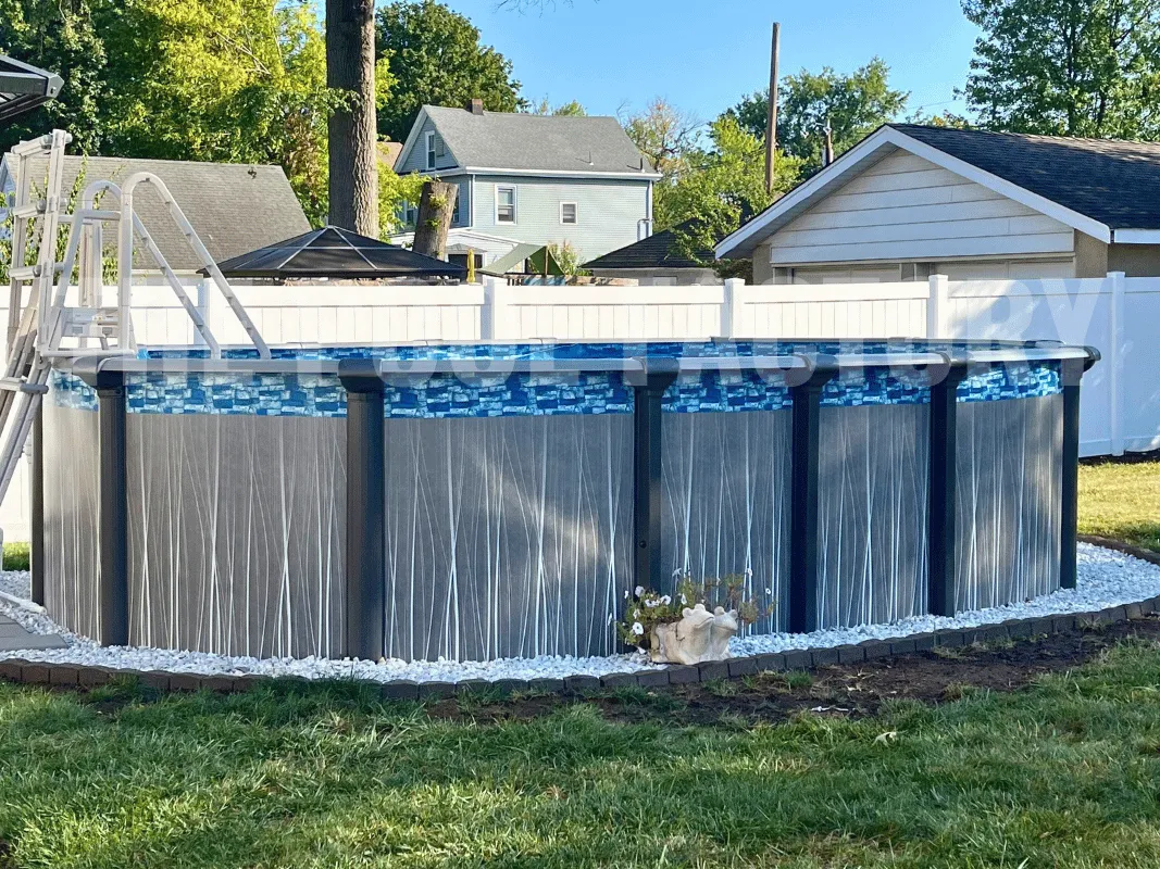 Above ground oval pool with decorative stone border and green grass