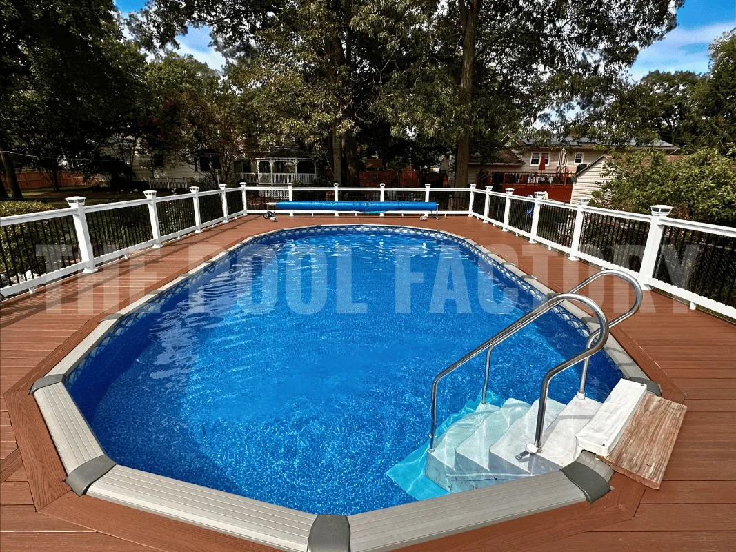 Backyard oval above ground pool with white railing and spacious deck