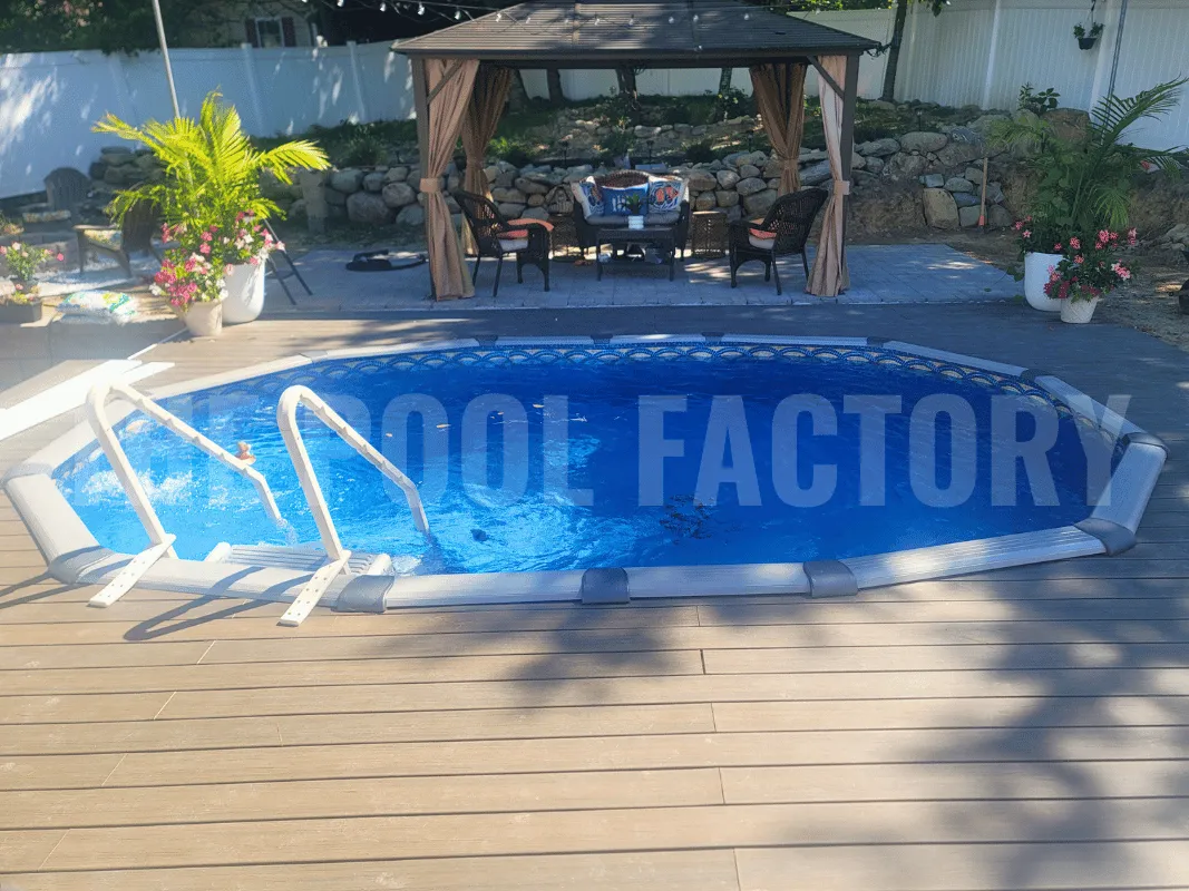 Oval above ground pool surrounded by wooden deck and privacy fence