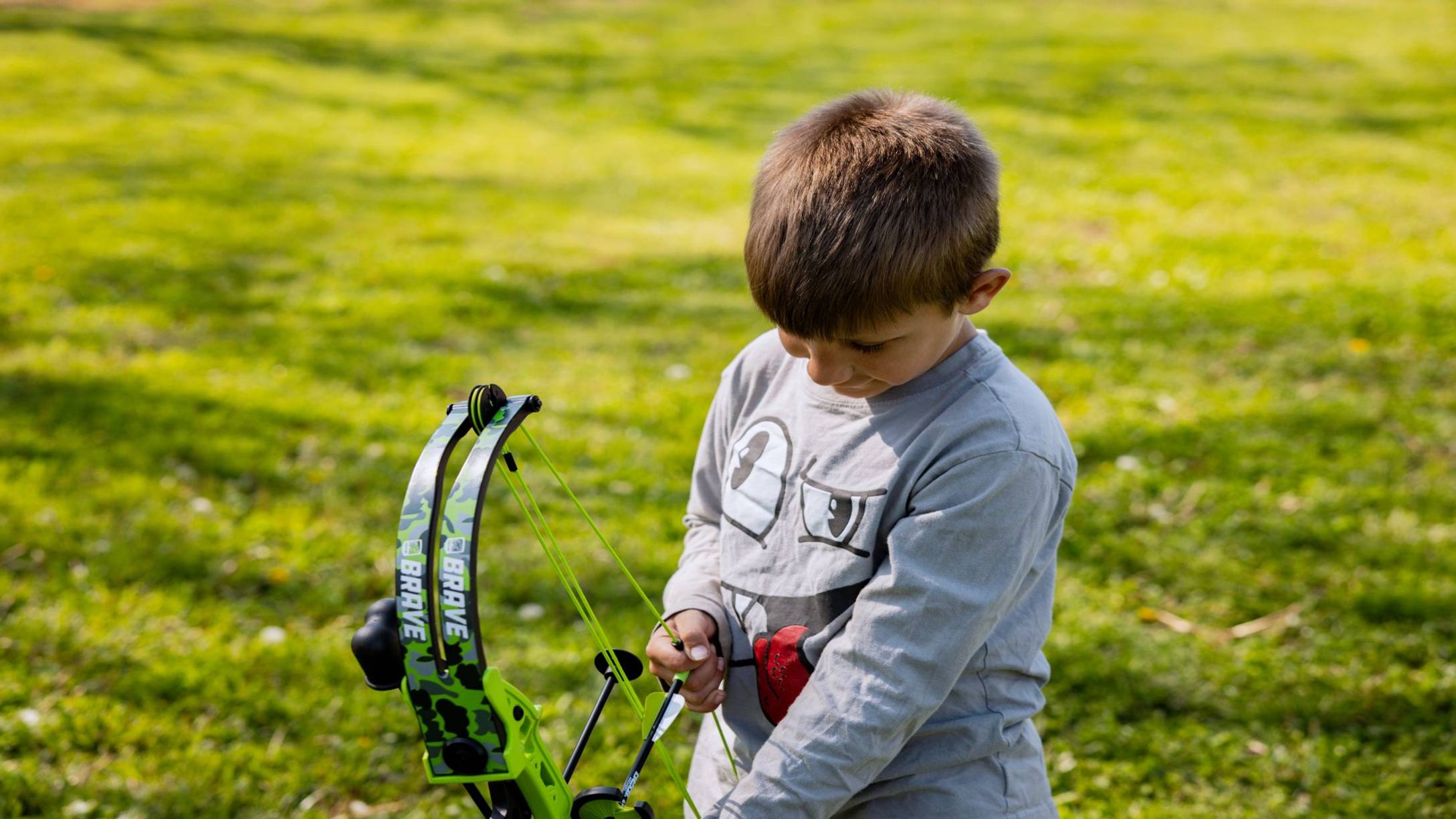 Boy holding the Bear Archery Brave youth bow in his hands.