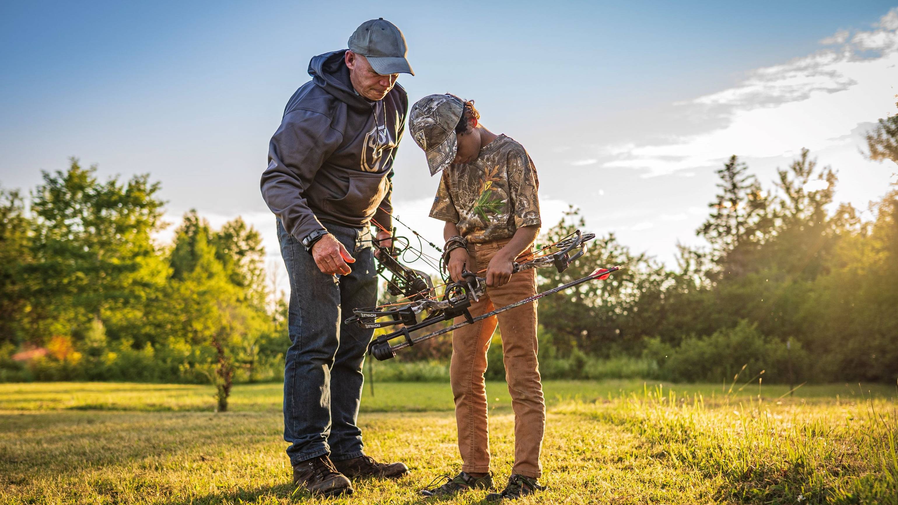 Father helping son shoot the Bear Archery Royal youth compound bow