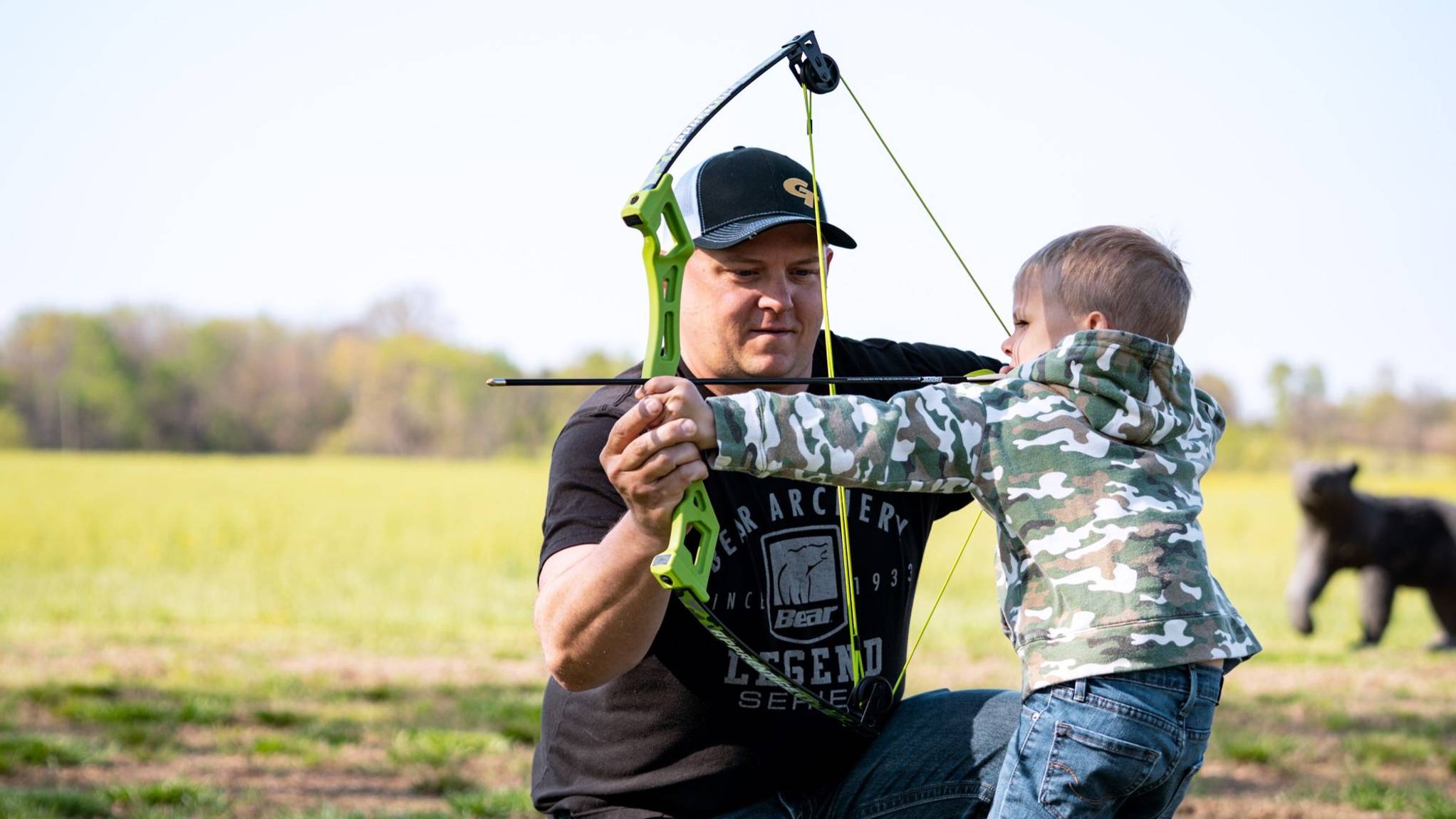 Father helping son shoot Apprentice youth archery bow from Bear Archery.