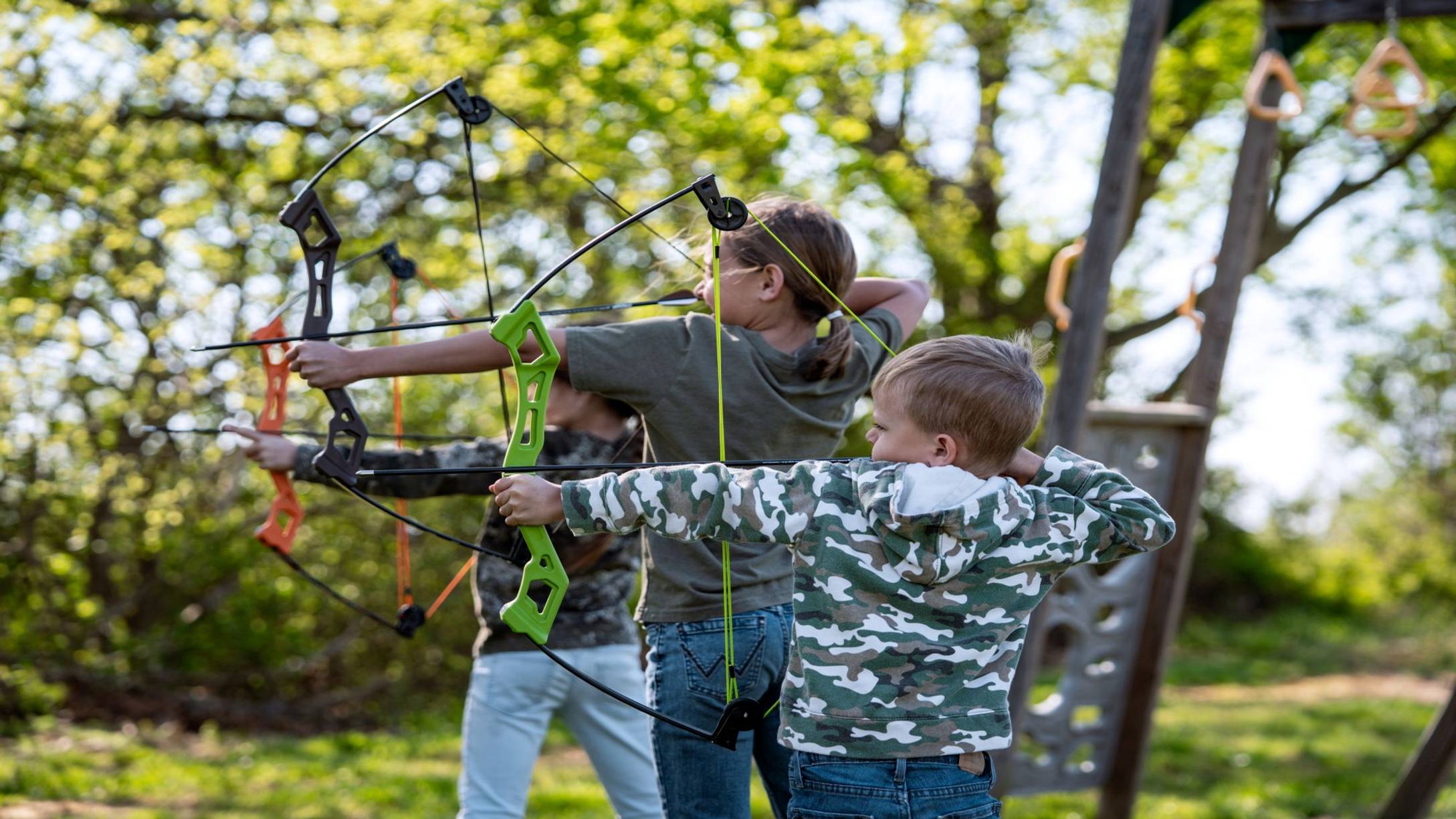 Group of three kids shooting the Bear Archery Apprentice youth bow.