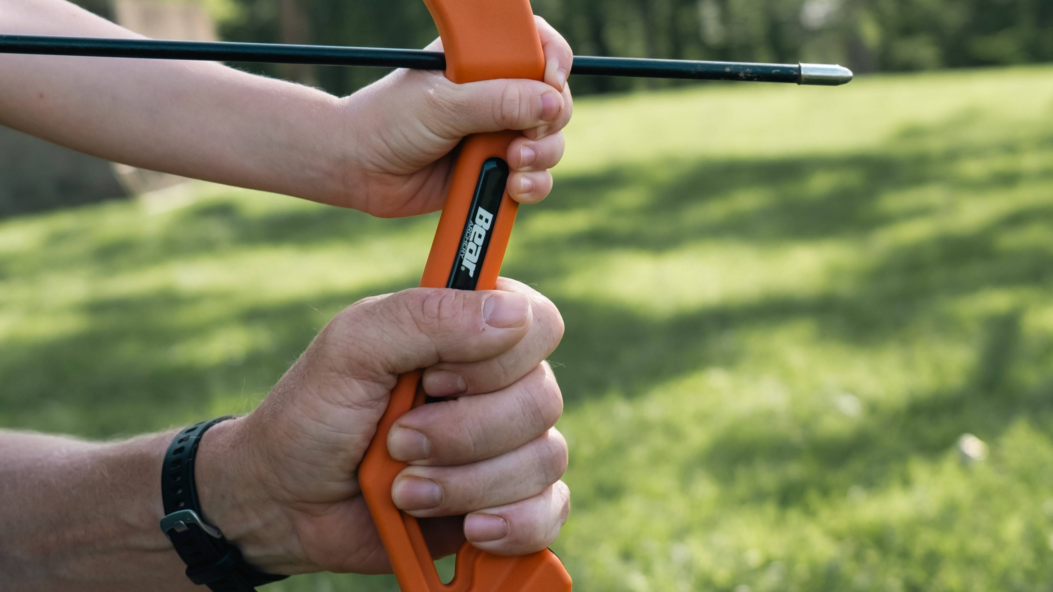 Close up of a dad and daughter holding the Apprentice youth bow from Bear Archery