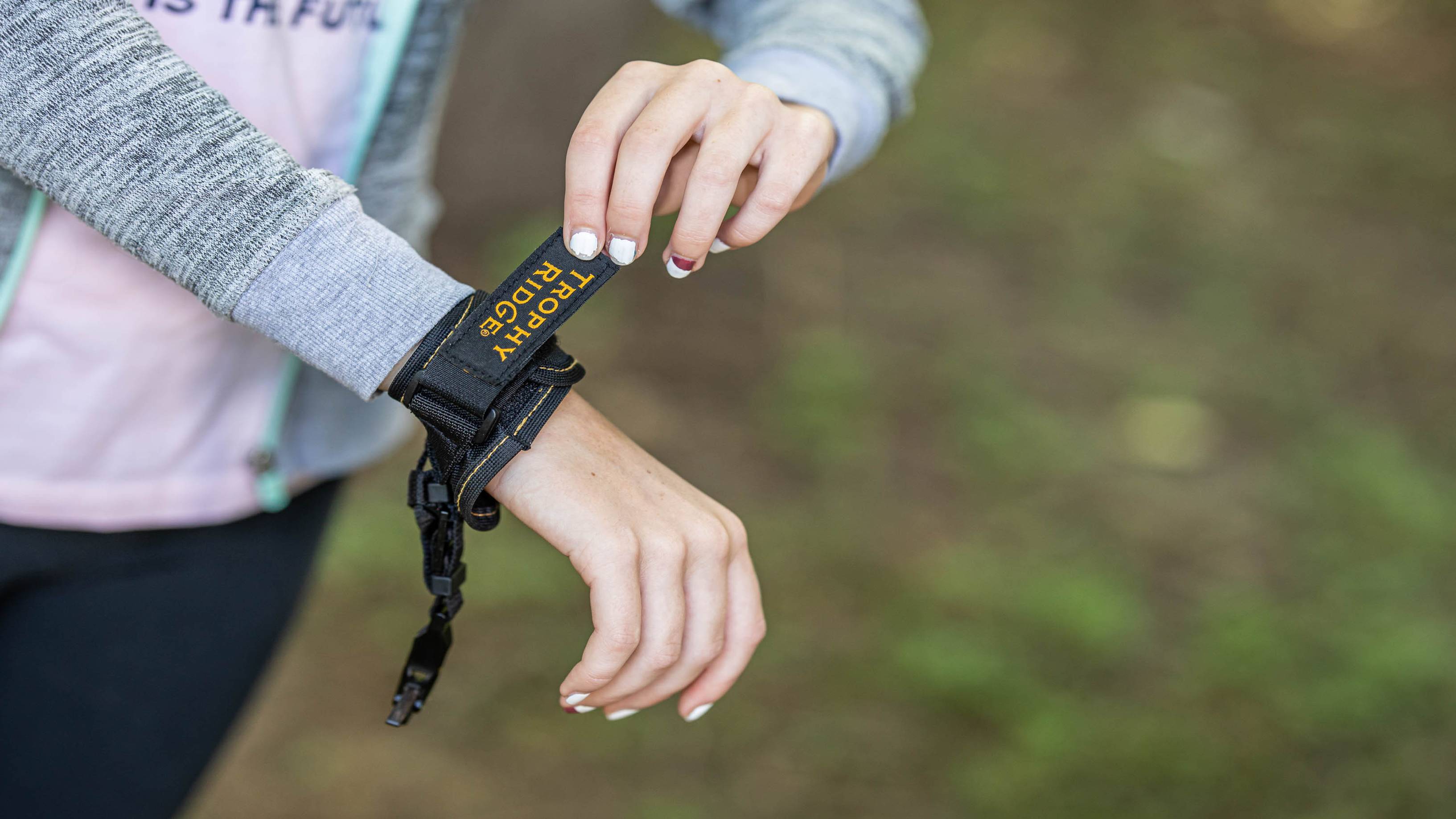 Young girl putting on the ArchX Youth wrist strap release from Trophy Ridge