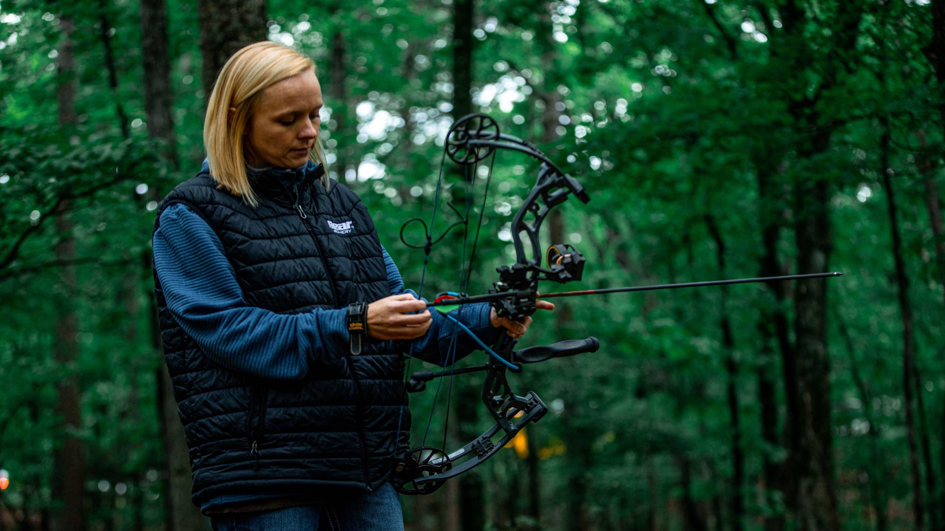 Woman nocking an arrow into the Bear Prowess women's compound bow from Bear Archery.