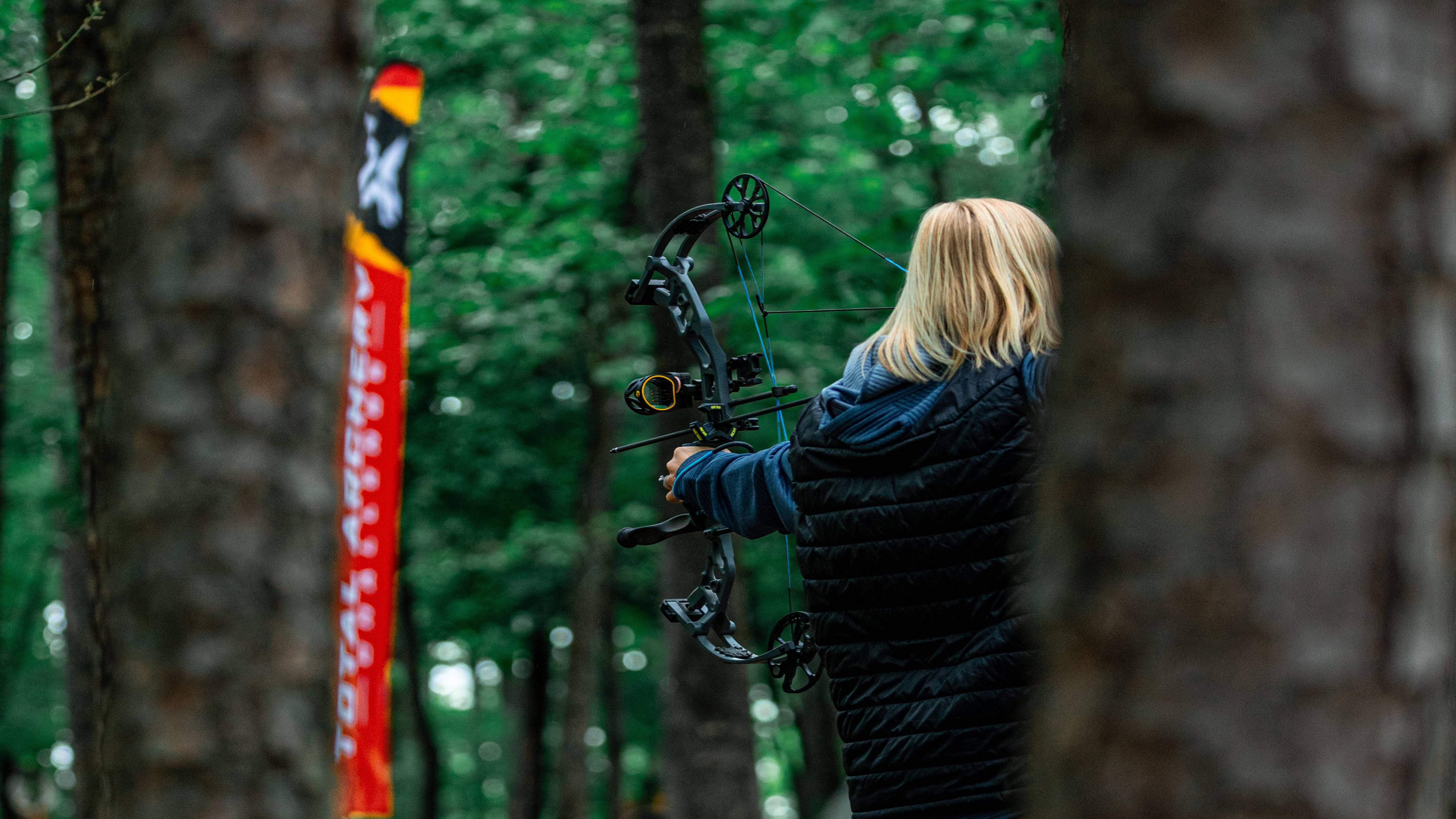 Woman shooting a Bear Archery Prowess compound bow.