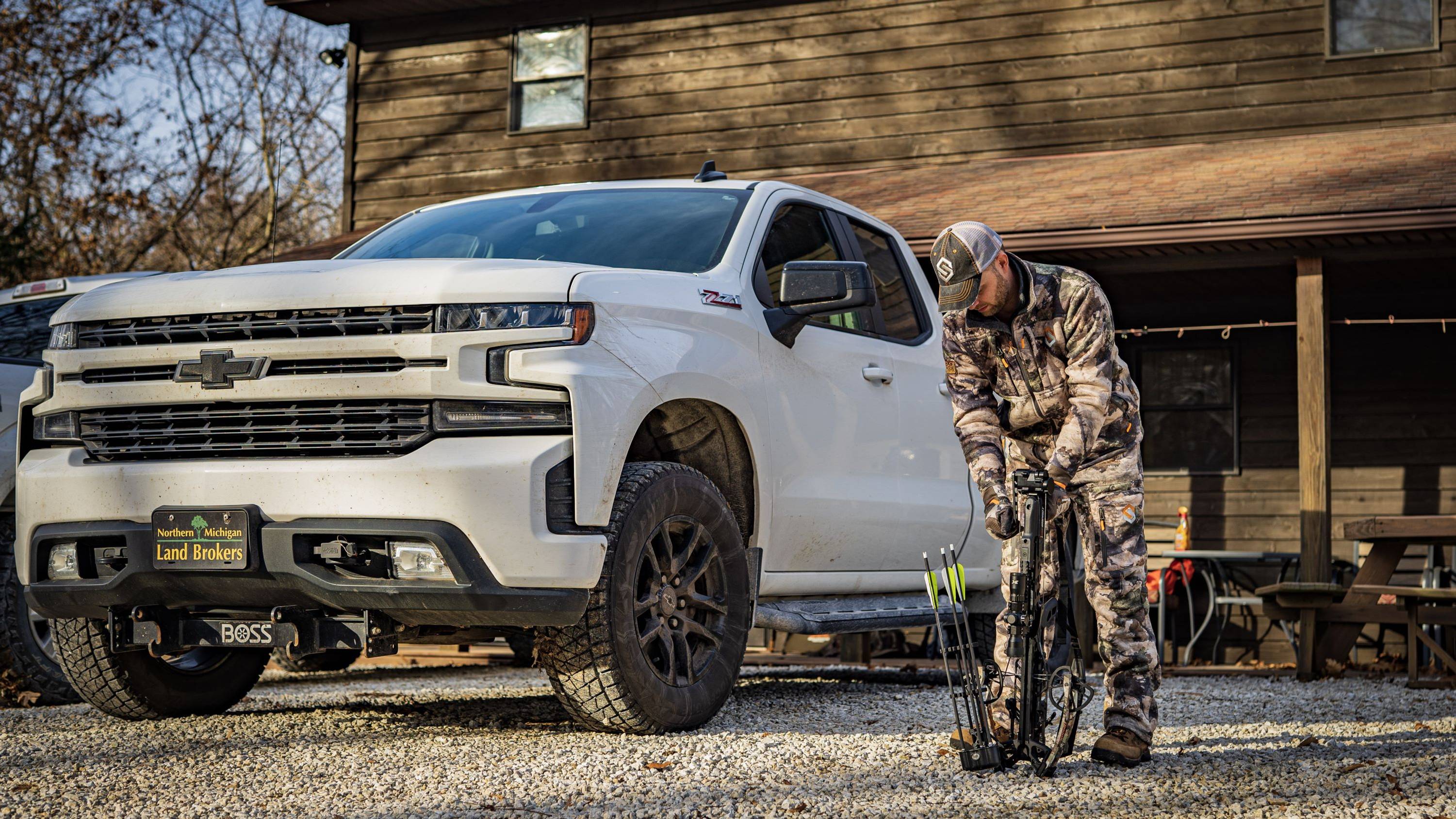 Man standing in front of a white truck with the BearX Impact crossbow