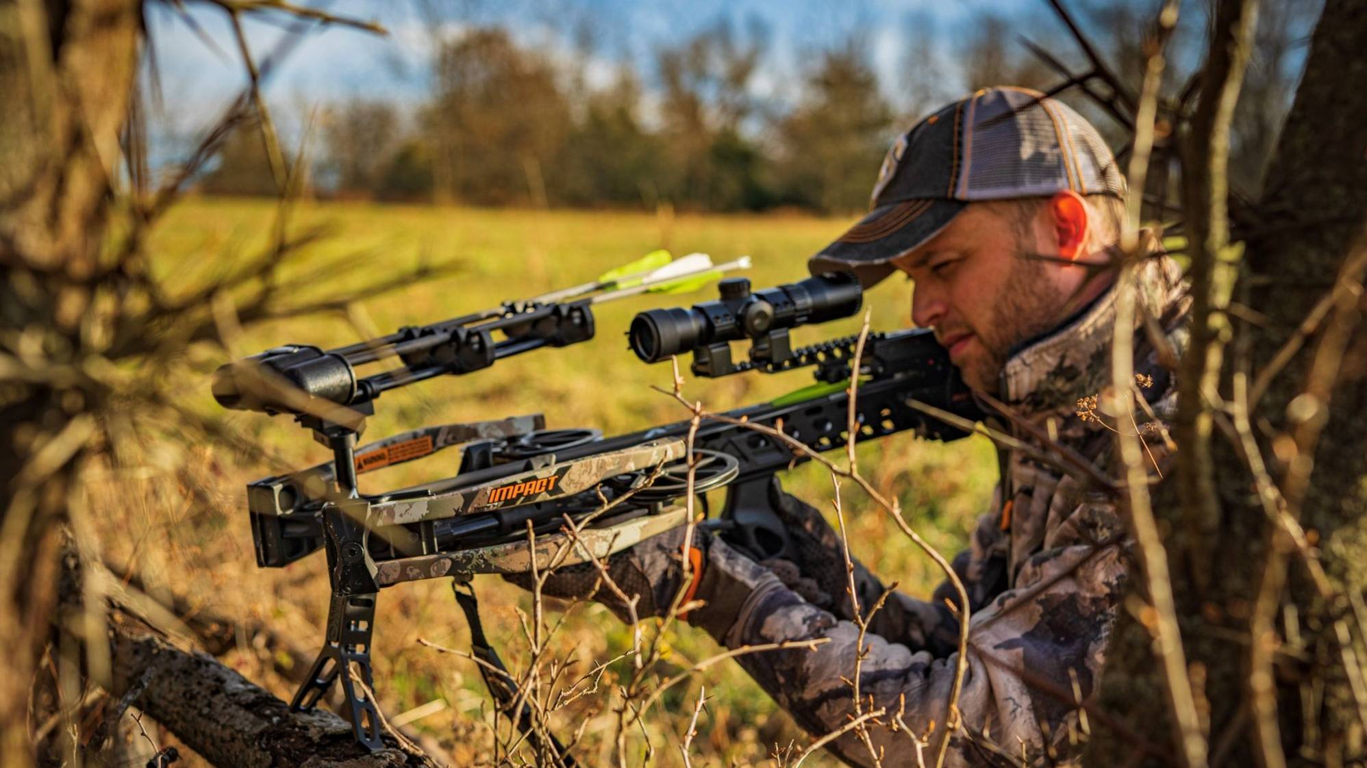 Man holding a crossbow looking through the Speed Comp Crossbow Scope from BearX. 