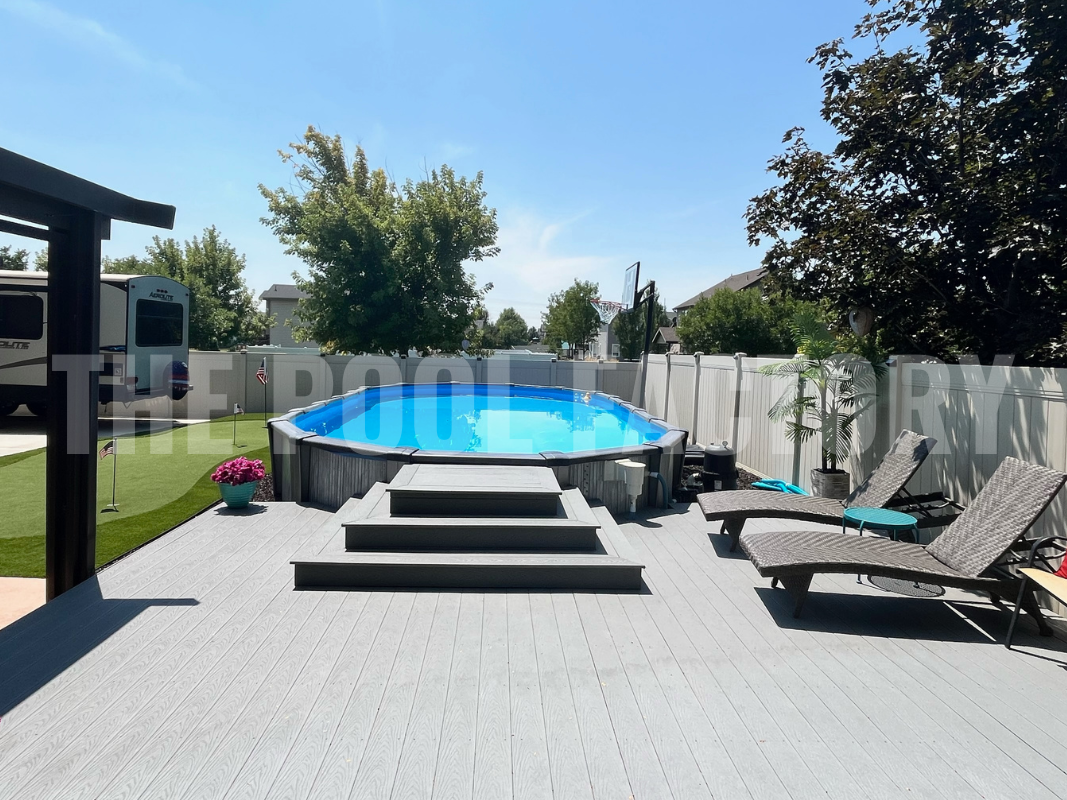 Oval swimming pool with deck, and lounge chairs on a bright sunny day