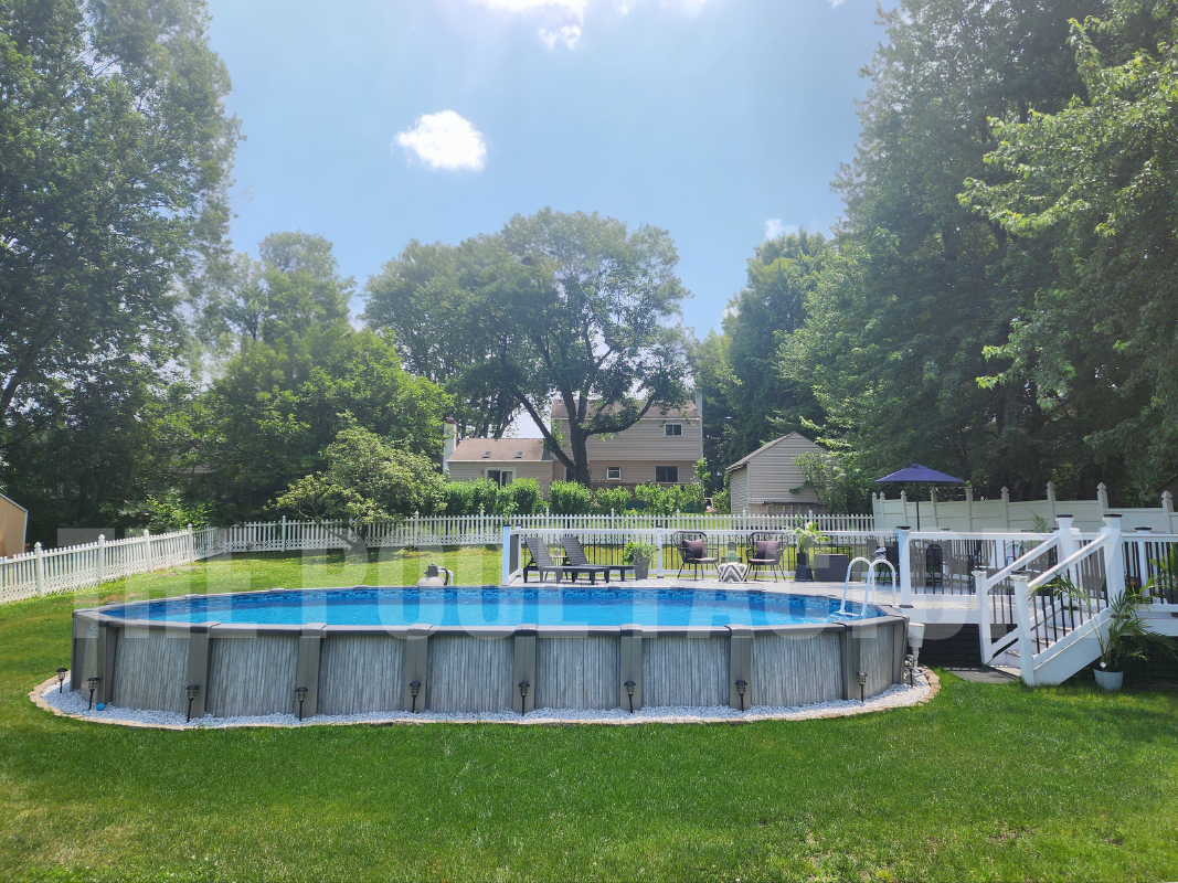 Above ground oval swimming pool with decorative rocks and vibrant backyard landscaping