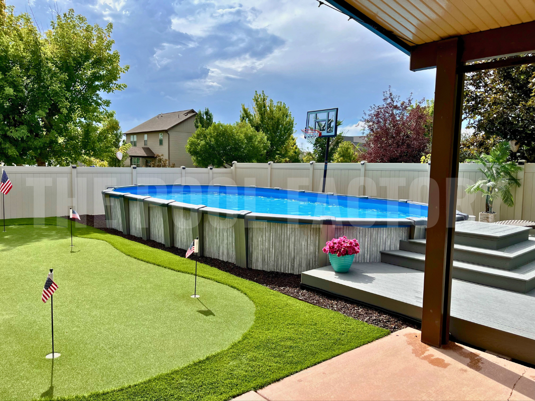 Backyard with oval swimming pool, deck, and colorful flower pots surrounding pool
