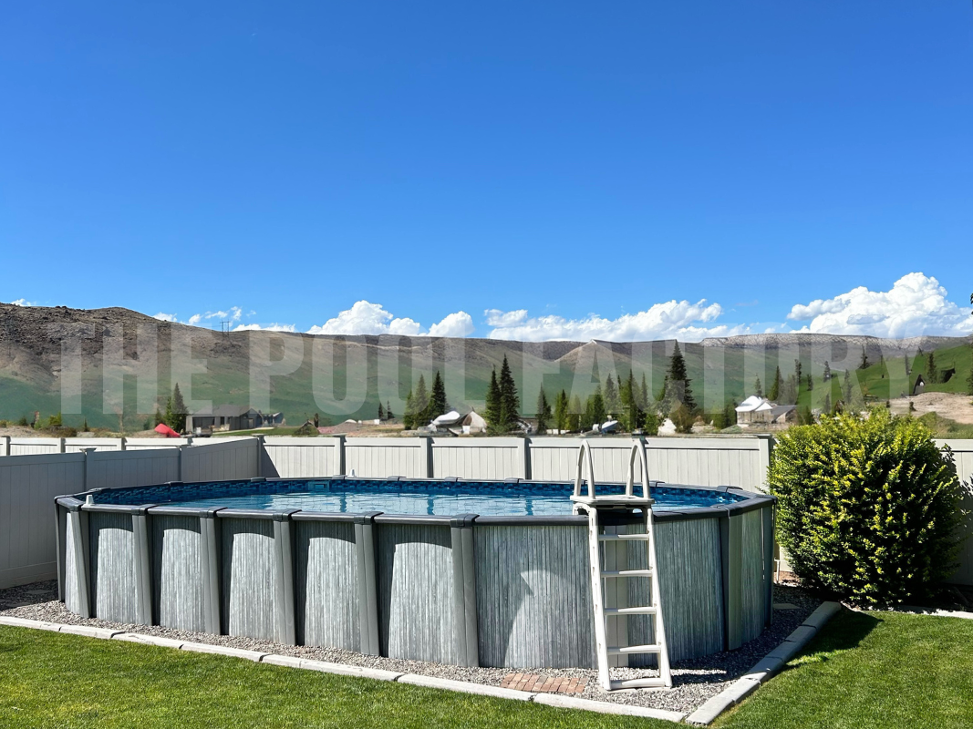 Oval above ground swimming pool with decorative rocks and mountain landscape
