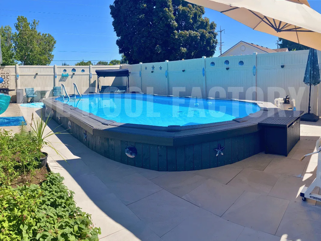 Oval outdoor pool with patio & deck and bright blue sky