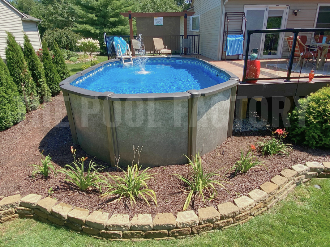 Above ground saltwater swimming pool with partial deck, mulch on a sunny day