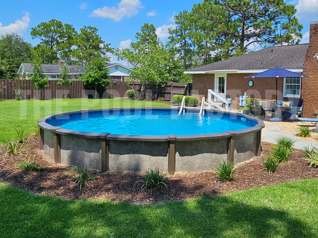 Round semi-inground swimming pool with shrubs and mulch