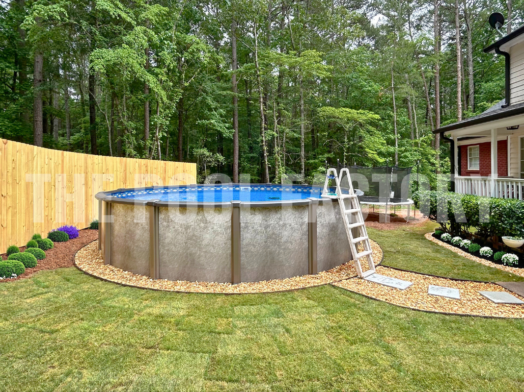 Round above ground saltwater pool with stone pathway and a wooden privacy fence