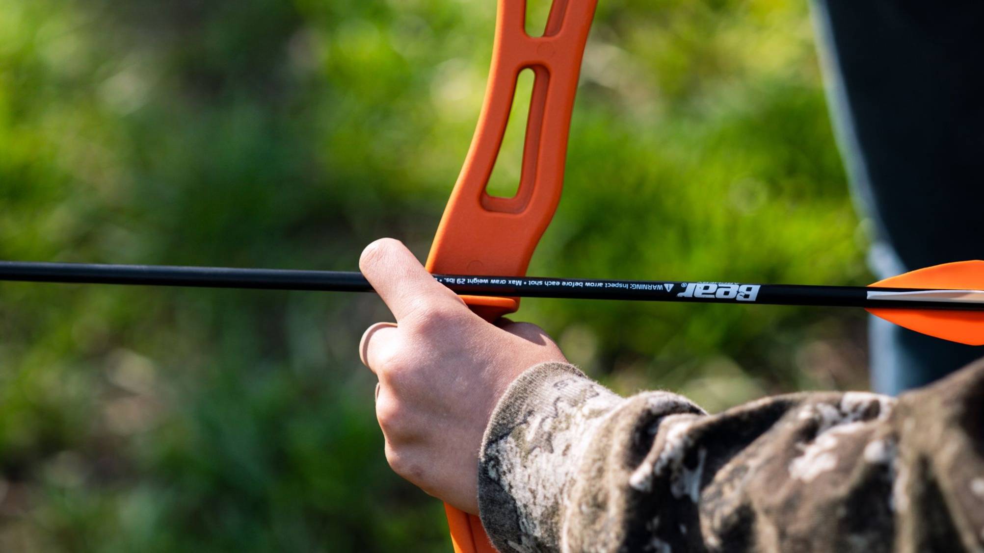 Close up of Youth Safetyglass Arrow from Bear Archery knocked on a youth bow.