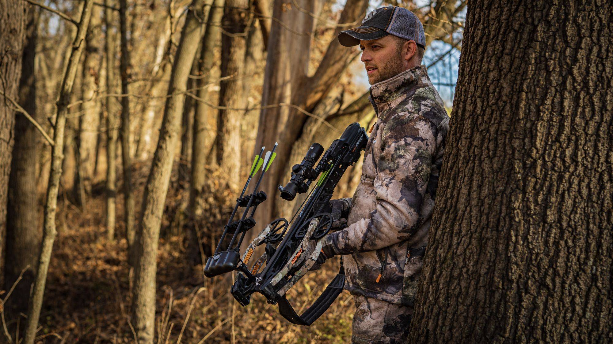 Man in tree stand with crossbow and TrueX crossbow bolts from BearX 