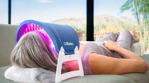 Women laying on her back using the Celluma LITE for aging to treat facial wrinkles using red light therapy.