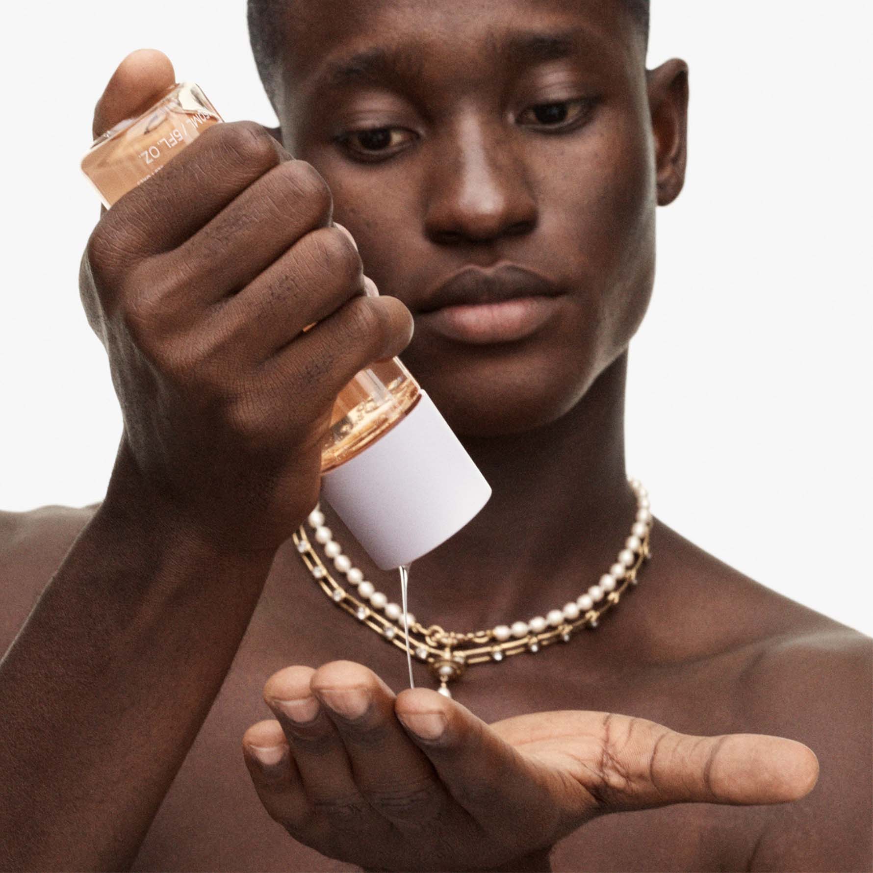 Model squeezing fat water toner serum into hands.