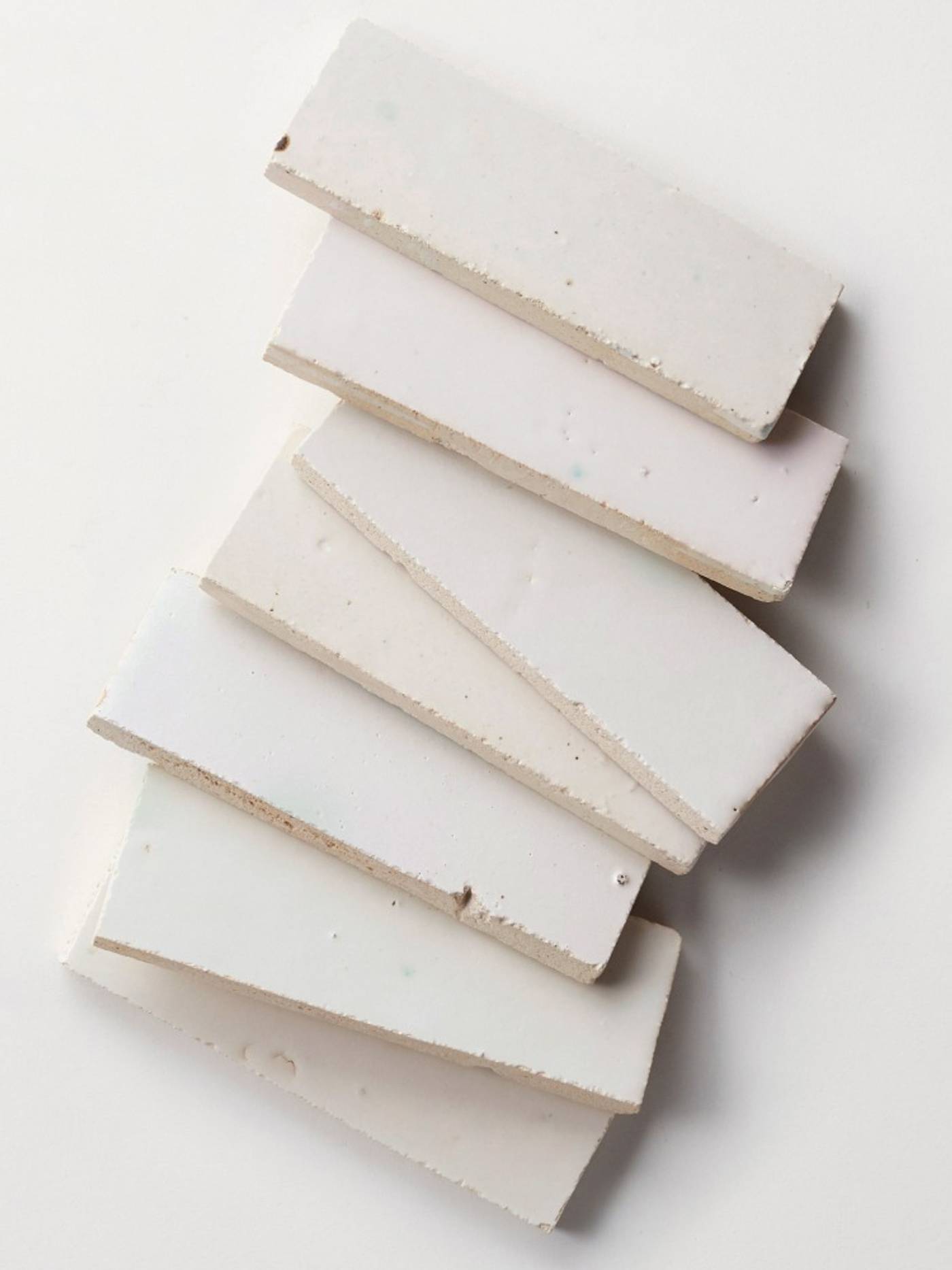 clé tile terracotta mochi white 2x6 tiles scattered in a row across the image

