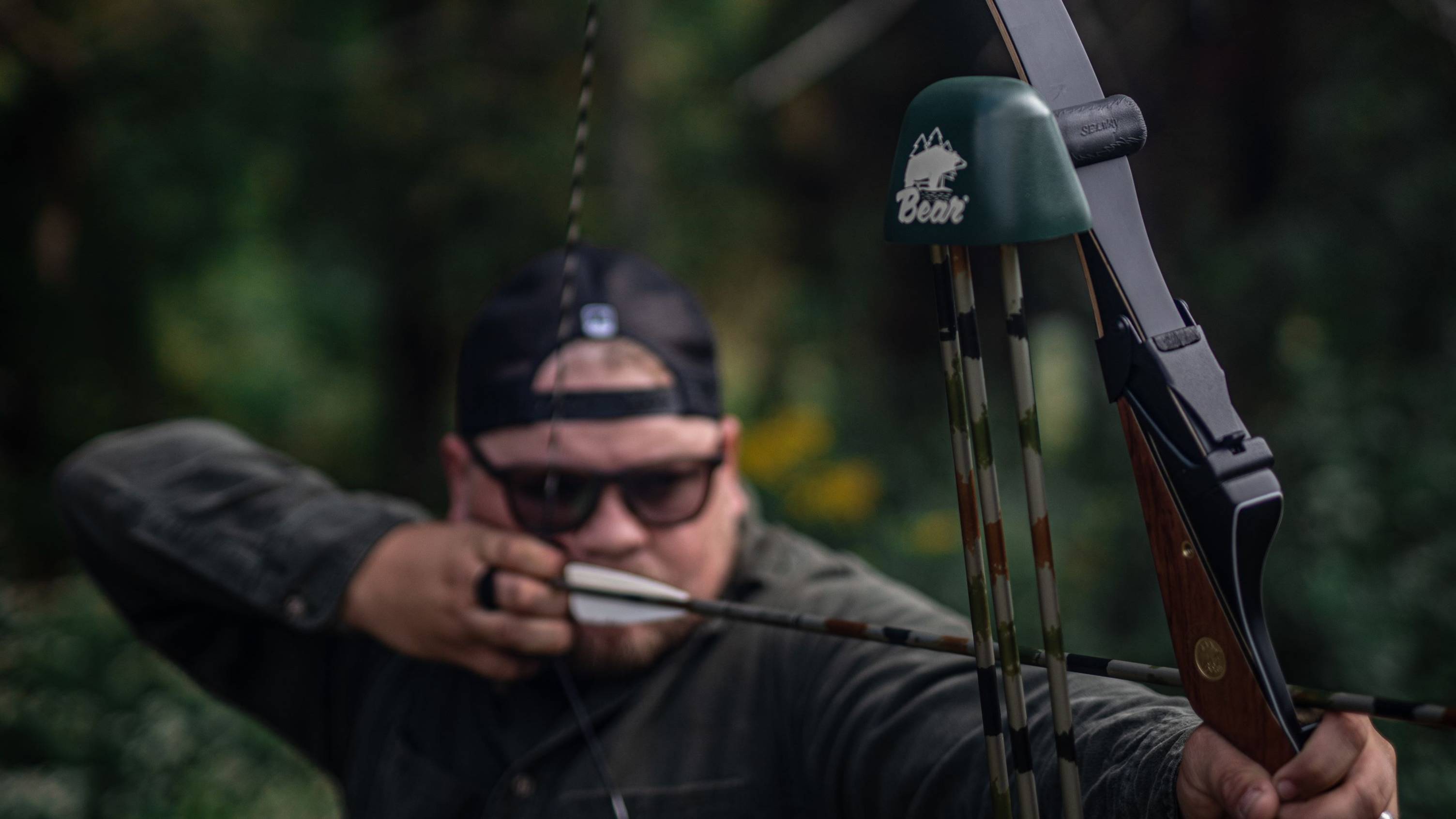 Man shooting a Bear Archery traditional bow with a Grayling Slip On Quiver