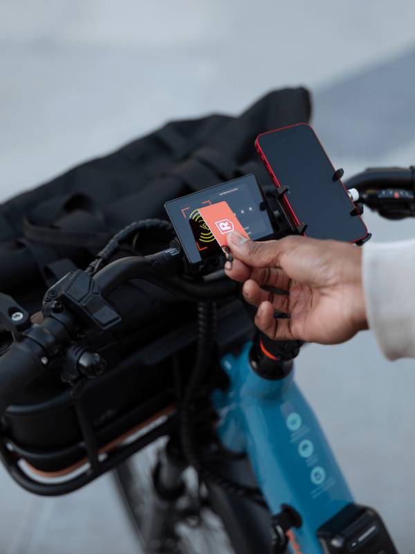 Person using a key card as a fob to unlock their ebike, shown with a Radster Road electric commuter bike.