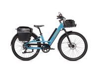 Blue Radster Road electric commuter bike with a pannier bag, front basket with liner bag, mirror and phone mount installed.