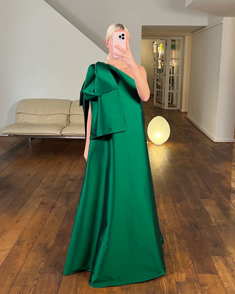 Bernadette Antwerp dress Winnie in emerald green is made from taffeta and features a bow on the shoulder. Floor length gown evening wear.