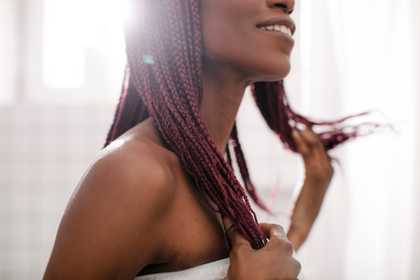 woman in a white towel flicking her braided hair