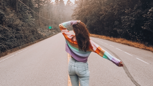 Happy woman walking, rainbow top, free of vaginal dryness