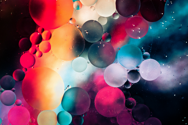 multi-coloured background with different size droplets over the lens creating a colourful abstract distortion