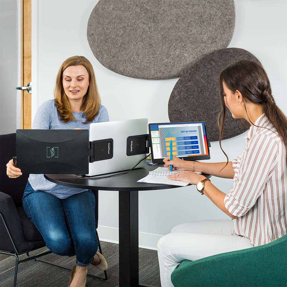 two coworkers sharing a sidetrak swivel multi monitor set up with hub