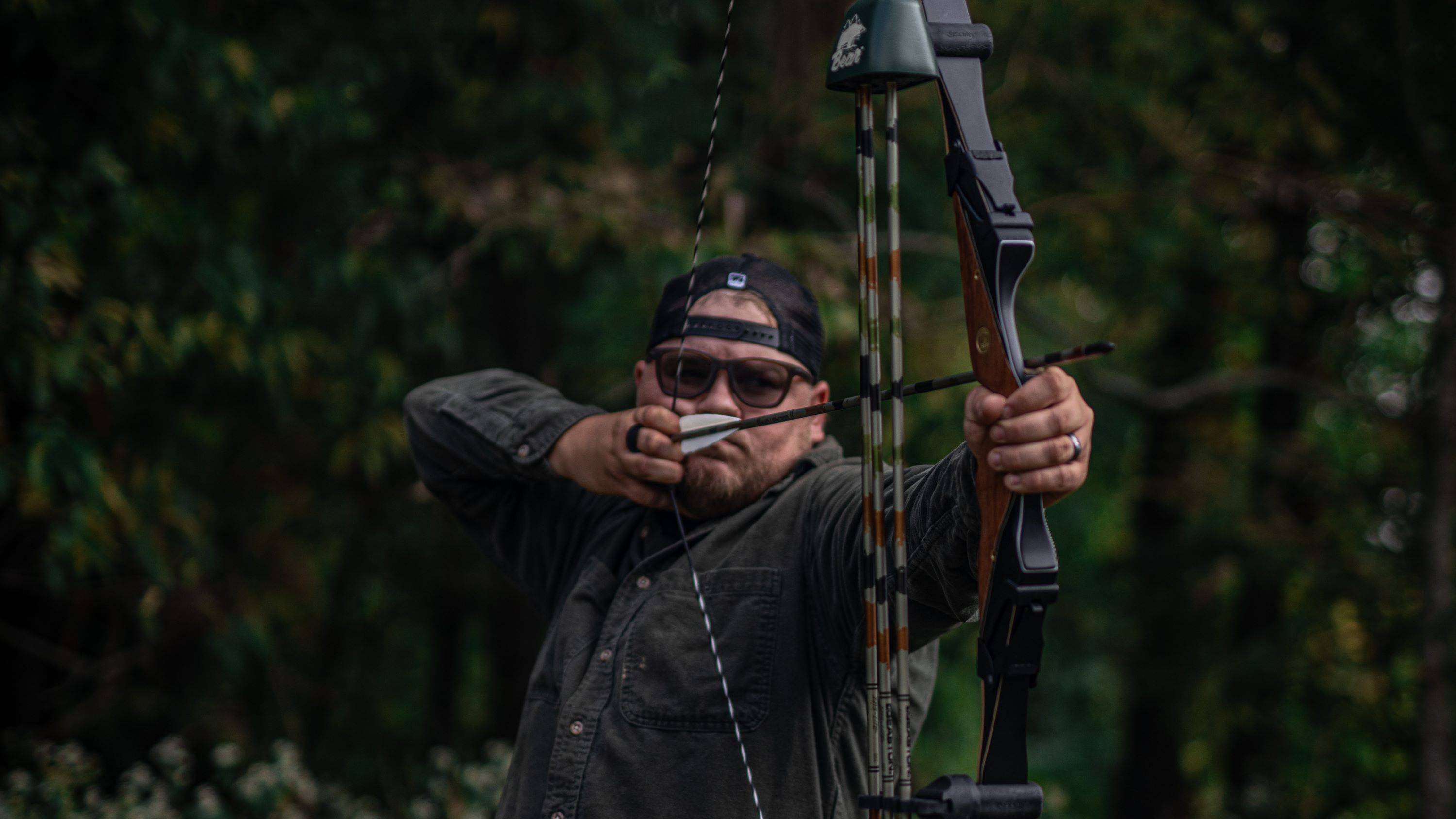 Man shooting a Fred Bear Take Down Riser from Bear Archery