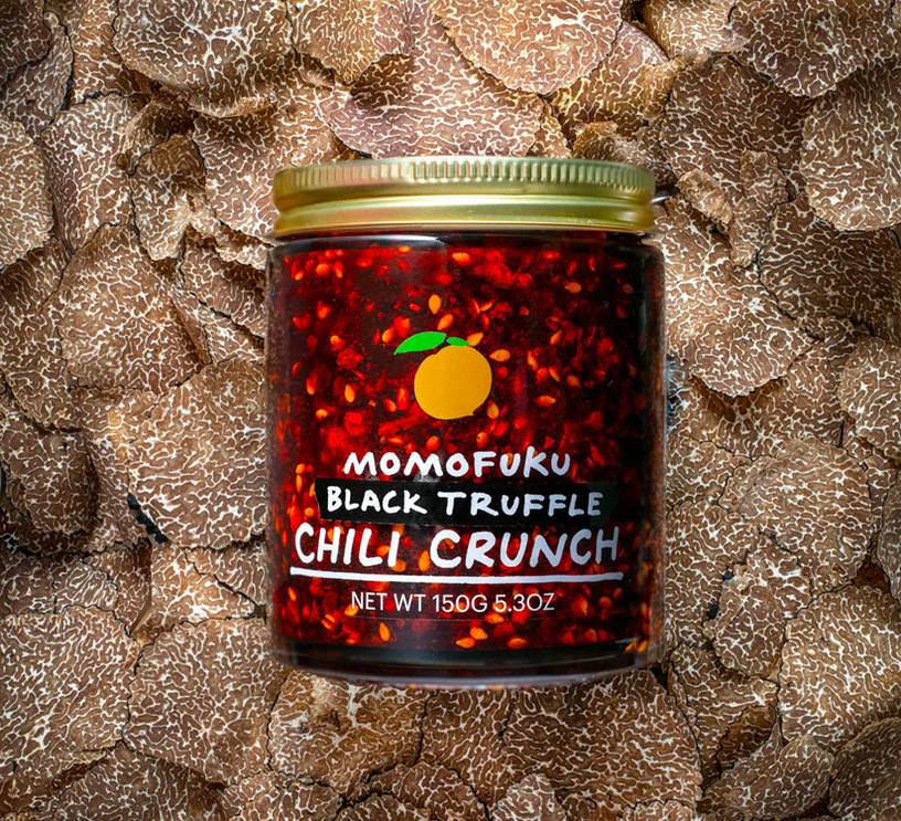 jar of black truffle chili crunch on a bed of truffles