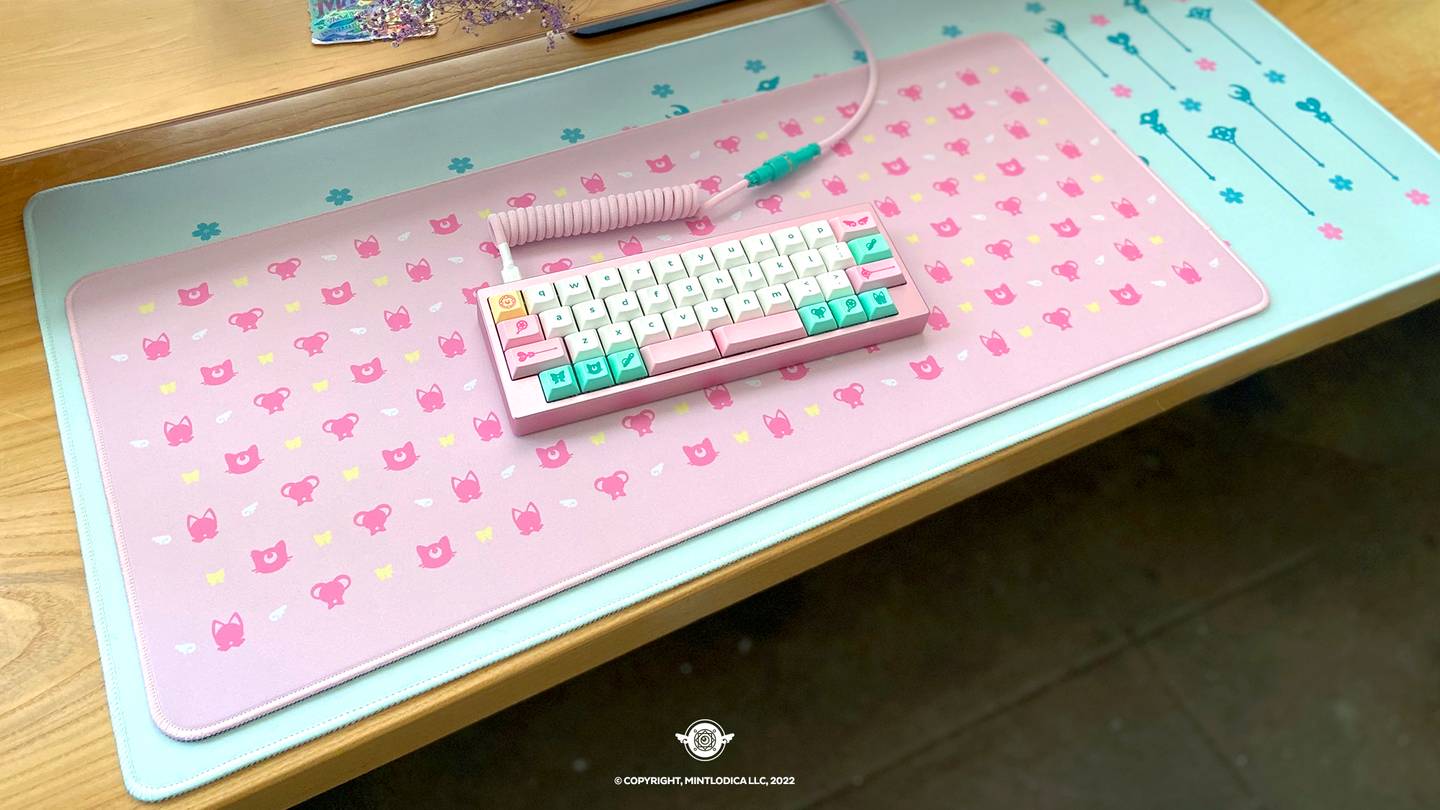 Photograph of Magic Girl by Mintlodica matching Deskmats or Deskpads in Pink Mini Deskmat on top of Mint Regular sized deskmat. There is a small pink Mechanical Keyboard on the pink desmat. matching the cute anime shoujo manga keycaps. featuring Wands, Familiars, Wings, Ribbons, and Magic Symbols.

