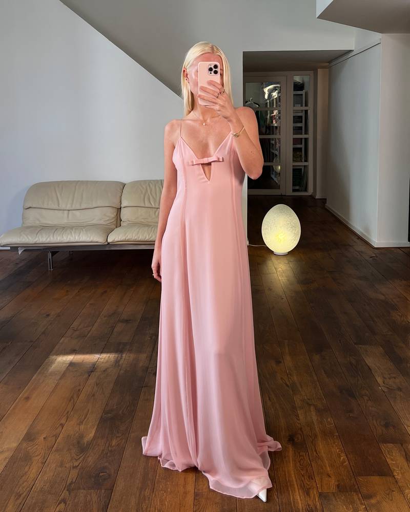 Bernadette Antwerp dress Mavis is made form silk and features a v-neckline with spaghetti straps and a bow, flowing into a floor-length gown. Color blush pink. 