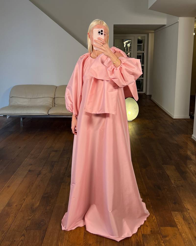 Bernadette Antwerp dress Victoria is a floor length gown made from taffeta fabric, featuring the signature BERNADETTE bow detail, poofy sleeves and a crew neckline. This evening wear dress is in the color warm pink. 