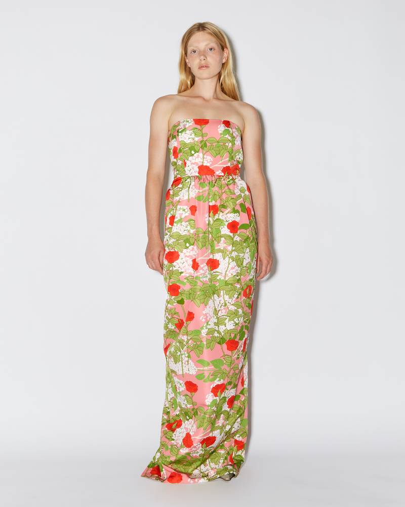 Bernadette Antwerp dress Lena is made from taffeta fabric, featuring a straight neckline, accentuated waist with detailing that flow into a fitted floor-length dress. Adorned with in-house drawn Lilacs and Climbing Roses print on a pink base. 
