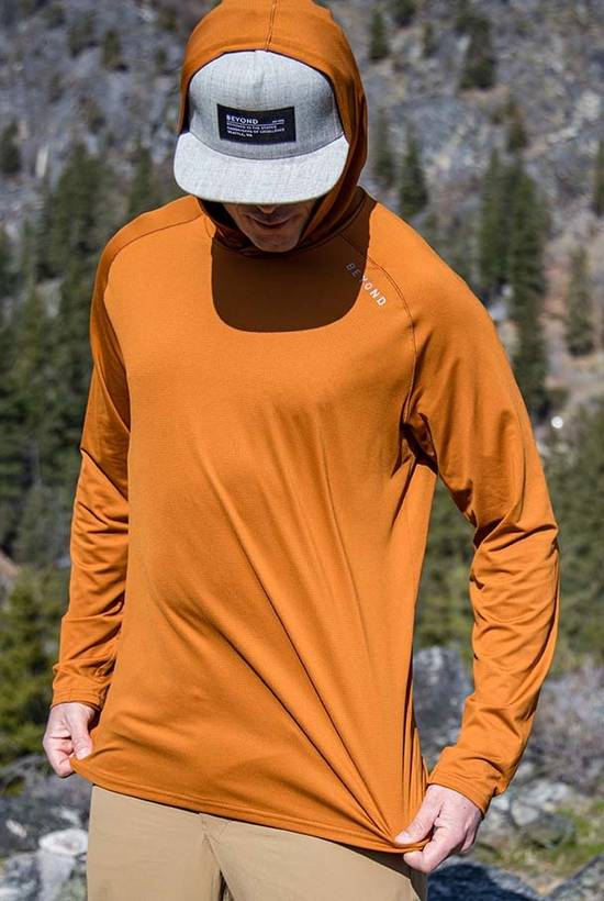 Man wearing Rust color Hooded Geo T LS Shirt showcasing the stretch