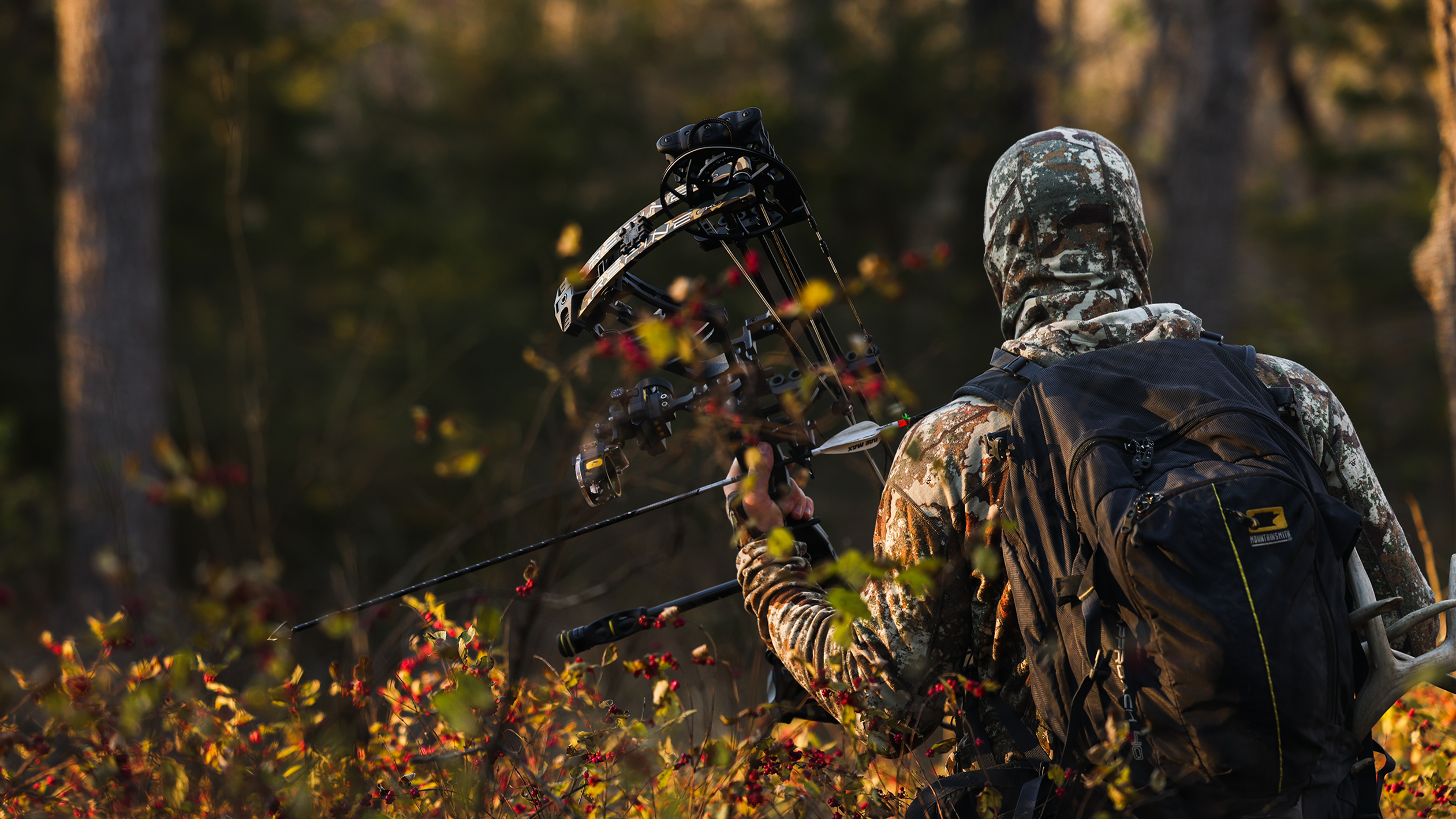 Man holding a Bear Archery bow with a Trophy Ridge Digital React® Trio Pro Bow Sight on it