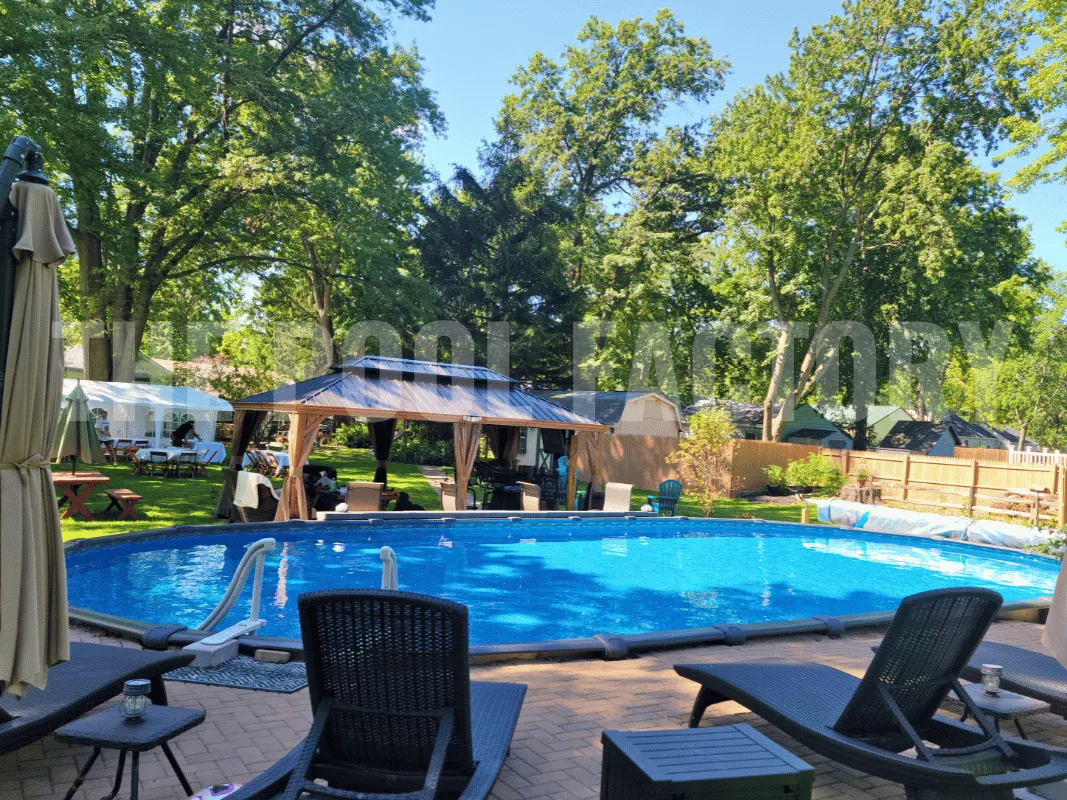 Backyard oasis with oval pool including wooden deck and lounging area with sun chairs