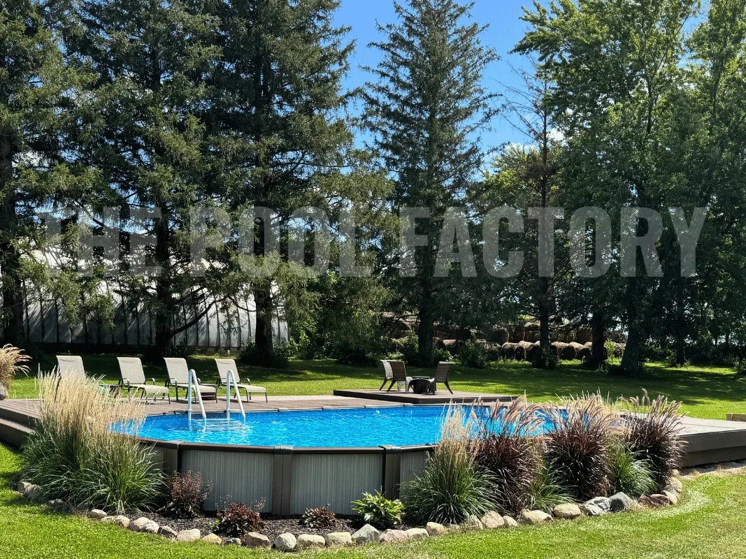 Oval above ground pool surrounded by wooden deck and lounge chairs
