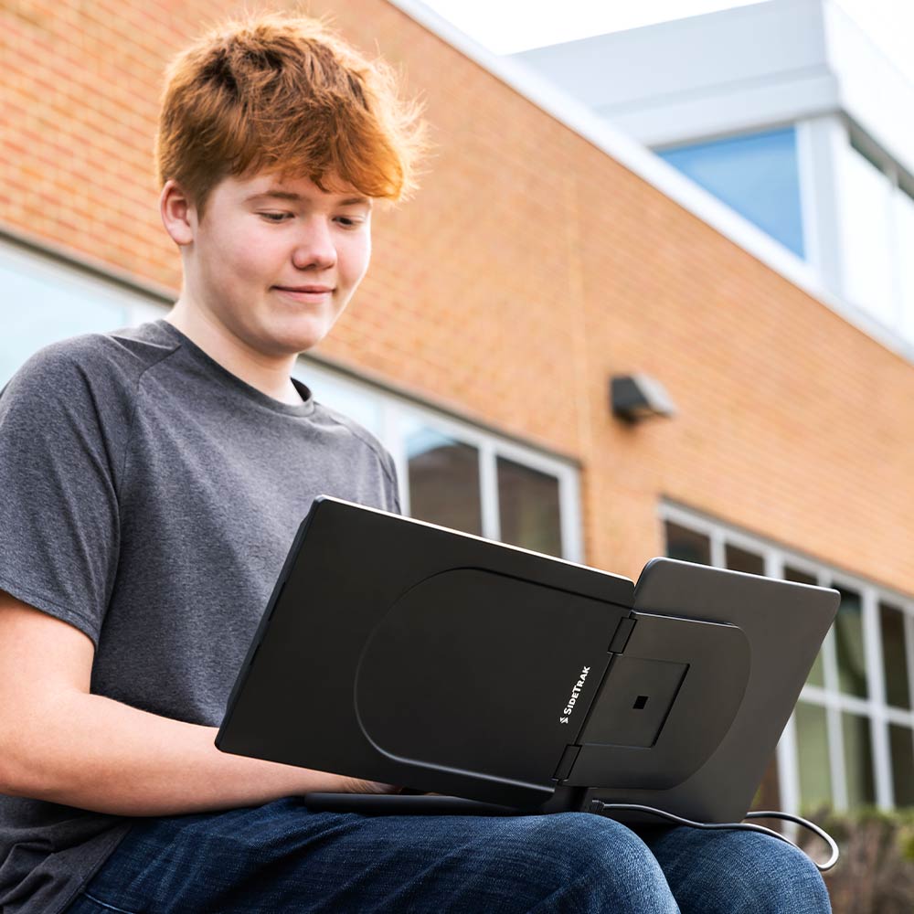 Photo of a student working outside on their SideTrak Swivel Essential portable monitor 