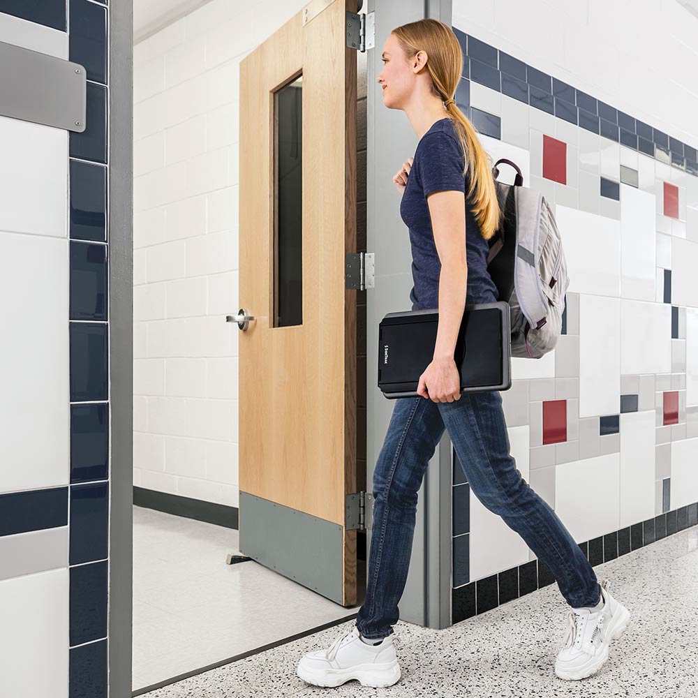 Photo of a student walking into a class with their SideTrak Swivel Essential portable monitor in hand 