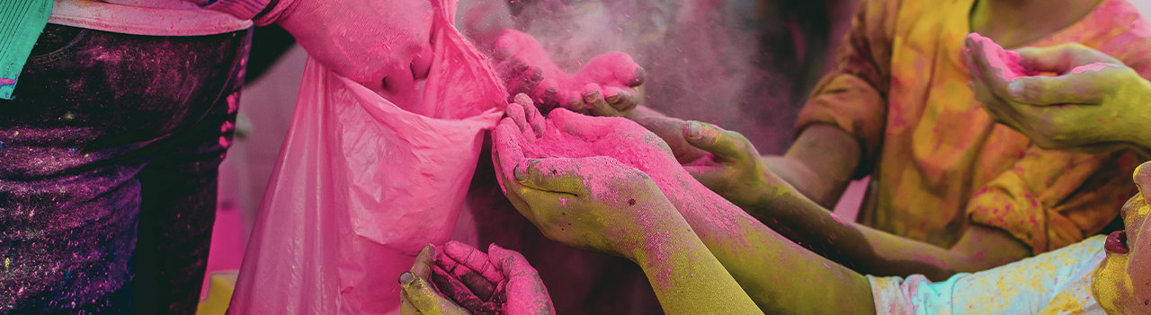 Adult giving a group of children colour powder
