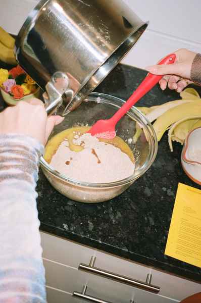 WHOLESALE Banana Cinnamon Cake Kit - (6 Unit Case)Editorial Image of person making cake