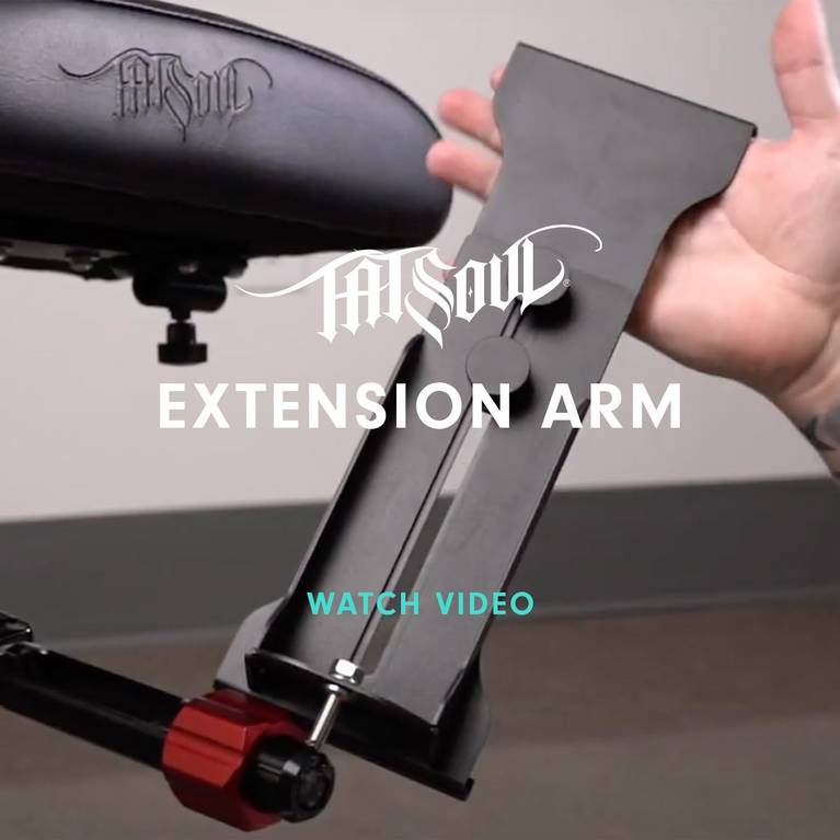 Tattoo chair extension arm being adjusted by a hand.