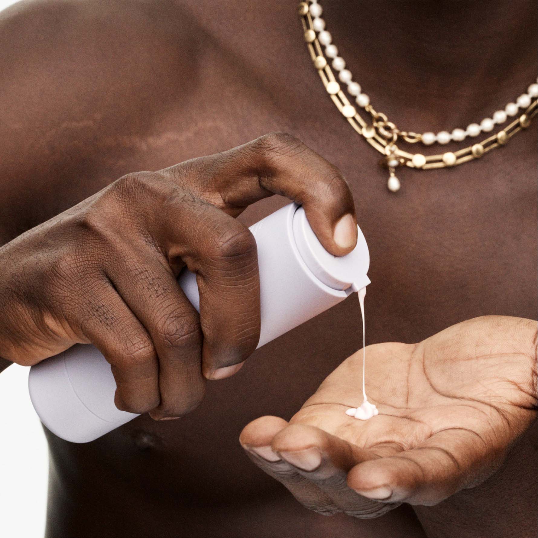 Model squeezing fat water toner serum into hands.